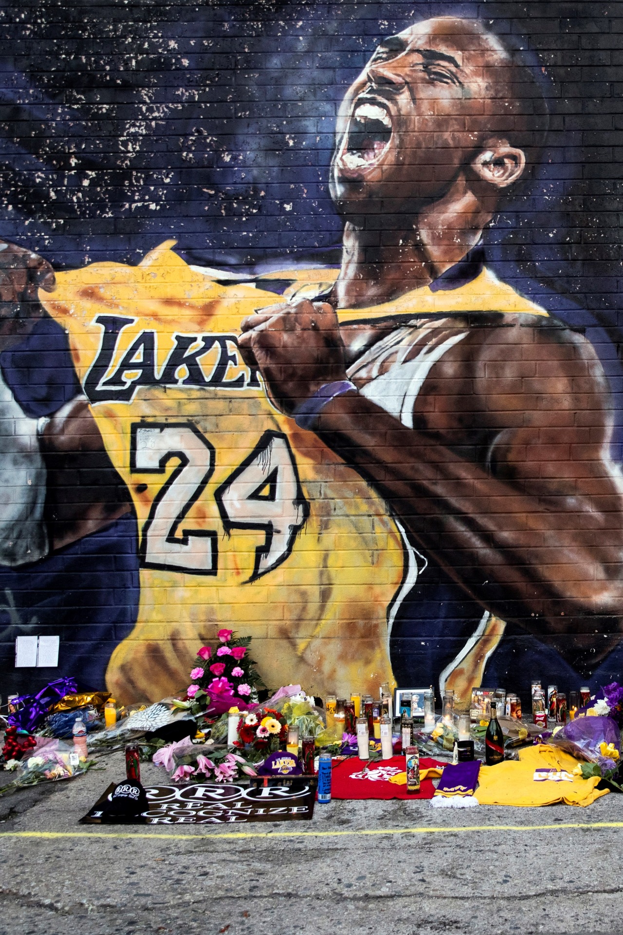 Flores y velas junto a un mural que rinde homenaje a Kobe Bryant cerca del Staples Center, el estadio de Los Ángeles Lakers. EFE/Etienne Laurent