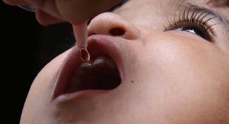 Un sanitario administra a un niño la vacuna oral contra la poliomielitis en la ciudad paquistaní de Karachi. EFE/EPA/REHAN KHAN