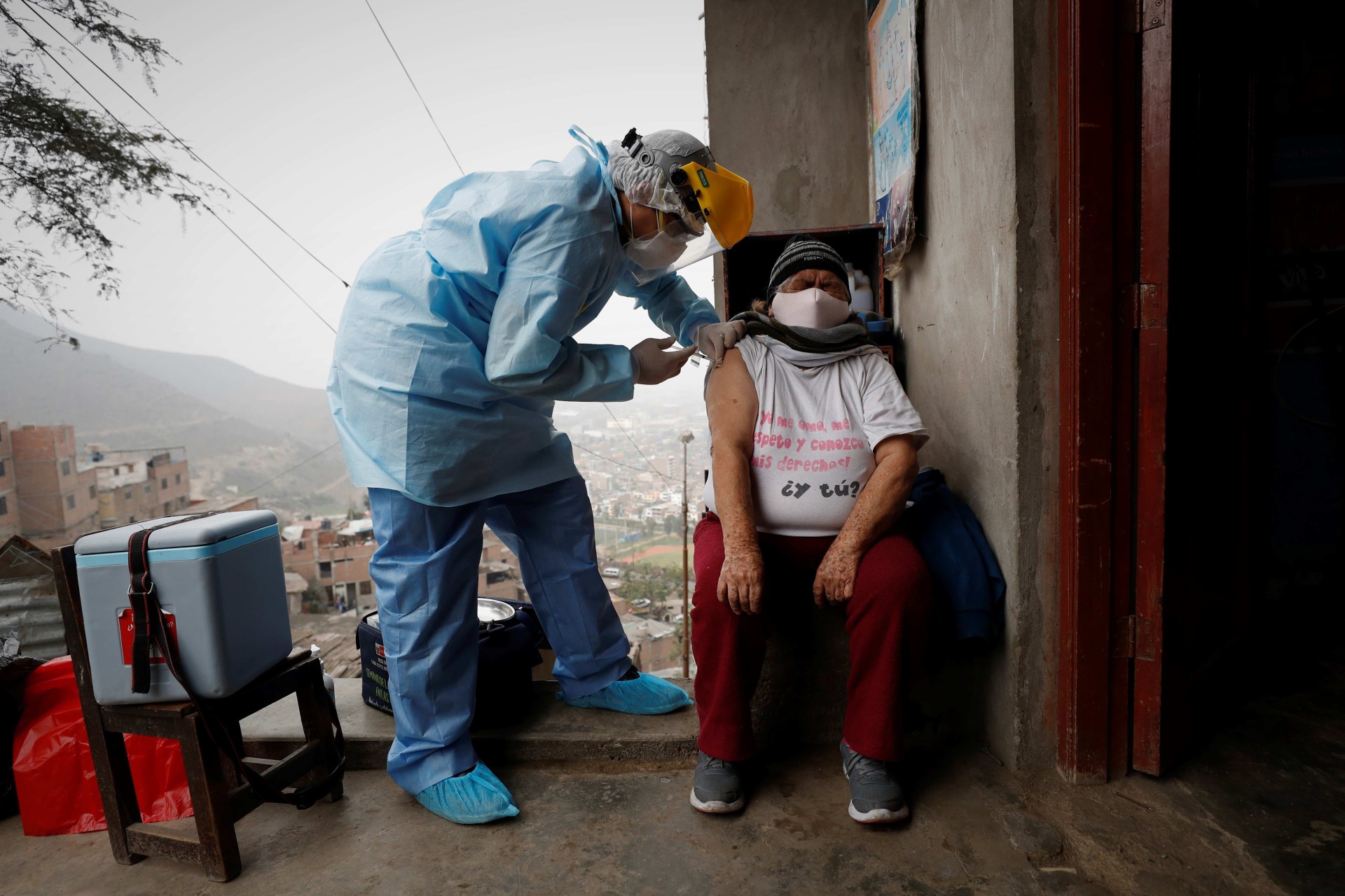Un enfermero coloca a un residente vacunas contra la gripe y la neumonía en Lima (Perú). EFE/Paolo Aguilar