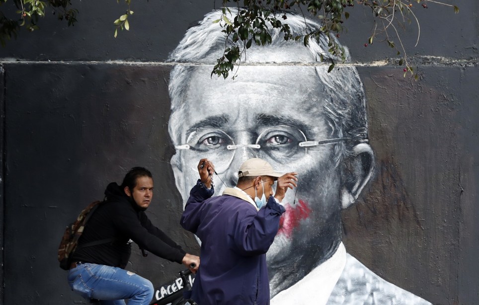 Dos personas pasan en Bogotá junto a un mural que representa al expresidente colombiano Álvaro Uribe. EFE/ Mauricio Dueñas Castañeda