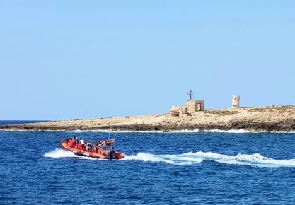Una lancha con voluntarios de una ONG de rescates y salvamento navega frente a la isla italiana de Lampedusa. EFE/EPA/Elio Desiderio