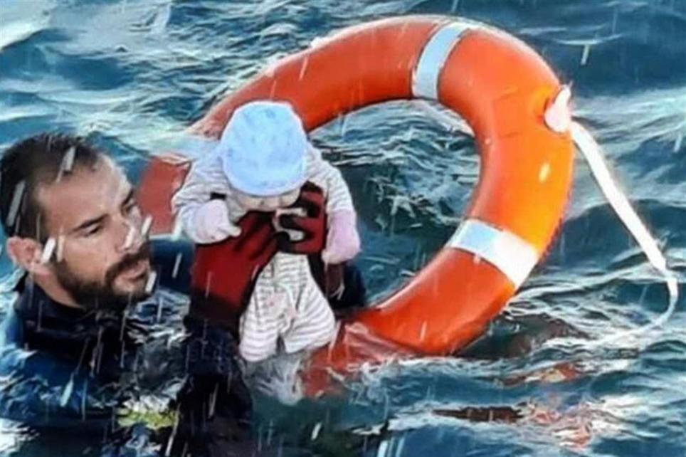 Un agente de la Guardia Civil rescata a un bebé del mar durante la crisis migratoria de Ceuta. EFE/ Twitter Guardia Civil.