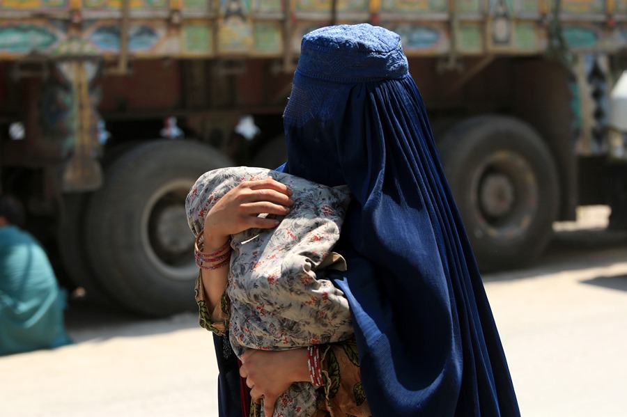 Imagen de una mujer afgana refugiada en Pakistán con su hijo